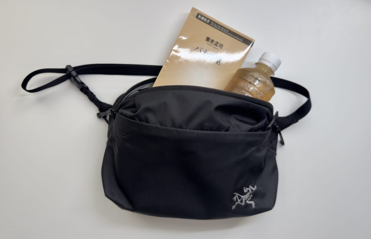 「Heliad Crossbody」に文庫本とペットボトルが入っている