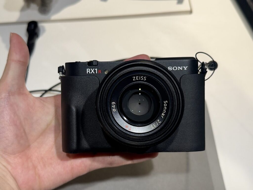 「RX1R III」に純正ボディケースを装着し手のひらの上に